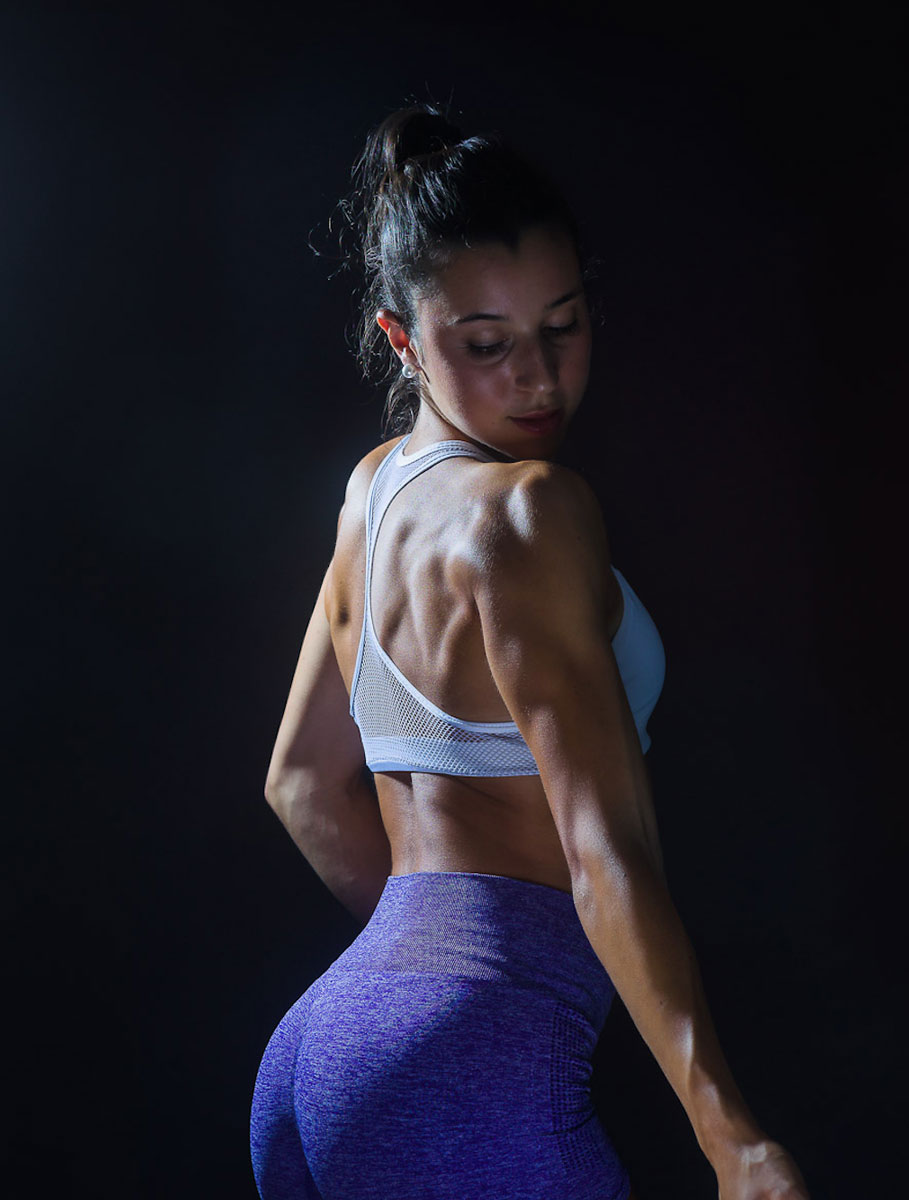 La entrenadora posa mientras muestra sus músculos.